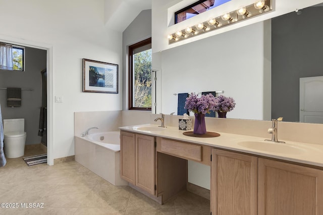 full bathroom featuring double vanity, a garden tub, toilet, and a sink