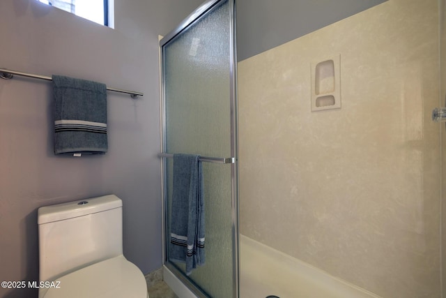 bathroom with a stall shower and toilet