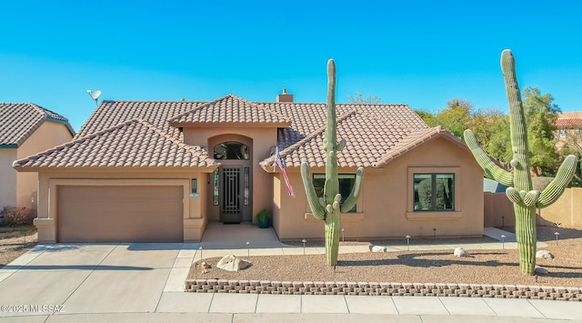 view of front of house featuring driveway, a chimney, a tiled roof, an attached garage, and stucco siding