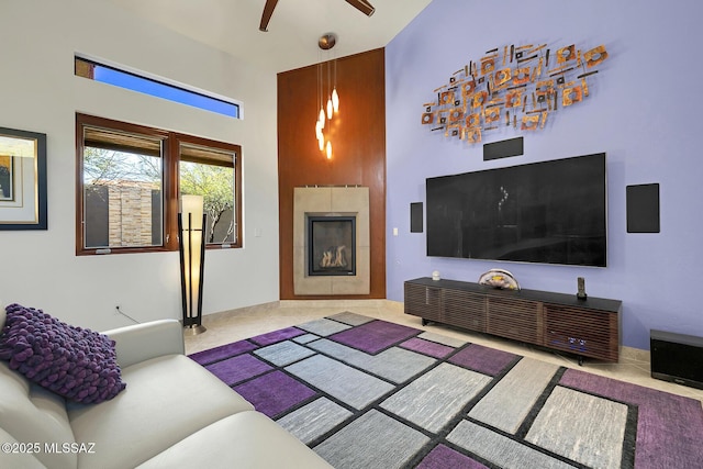 living room featuring ceiling fan, a fireplace, and carpet flooring