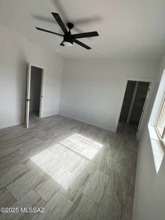 interior space featuring a walk in closet and ceiling fan