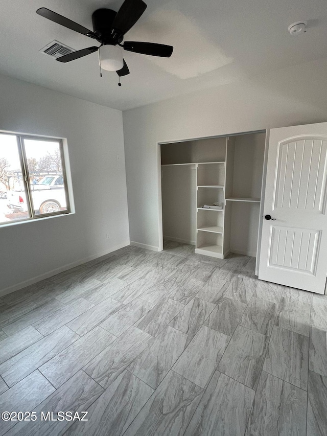 unfurnished bedroom featuring ceiling fan and a closet