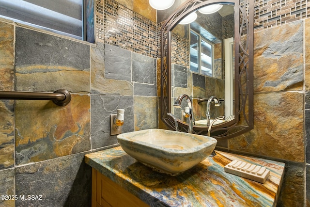 bathroom featuring vanity and tile walls