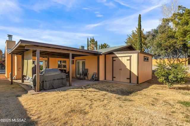 rear view of house featuring a shed, a lawn, and a patio