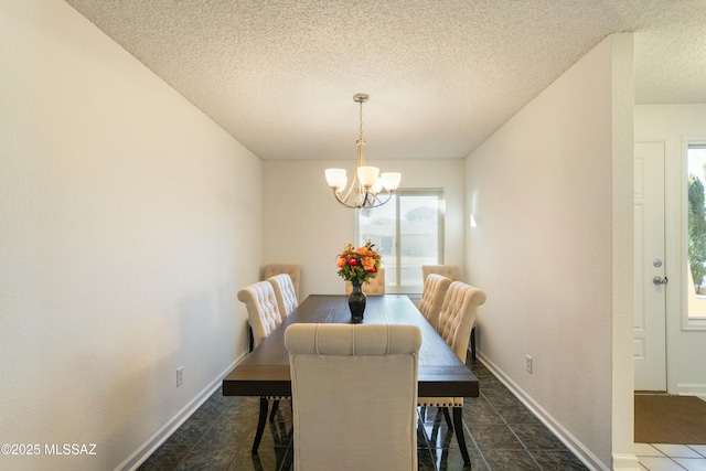 dining space featuring a chandelier and a textured ceiling