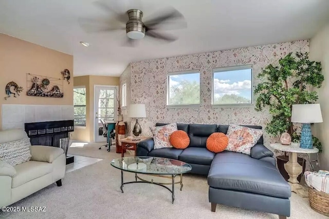 living room featuring carpet floors, a fireplace, and ceiling fan