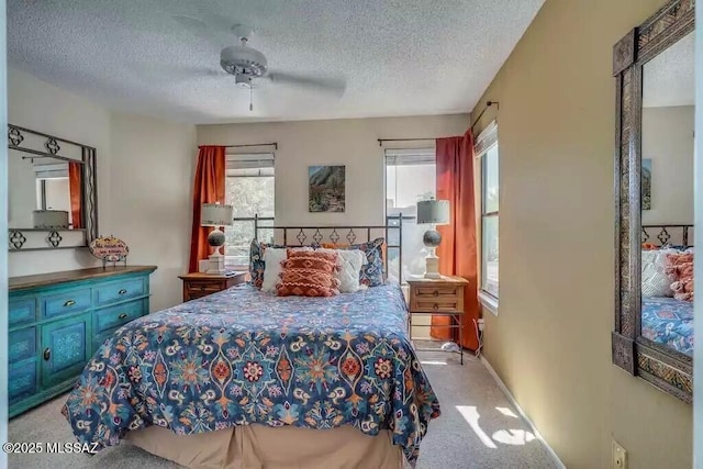 carpeted bedroom with ceiling fan and a textured ceiling