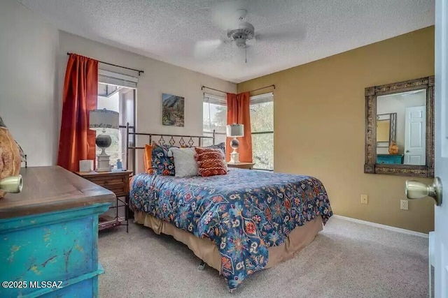 carpeted bedroom with ceiling fan and a textured ceiling