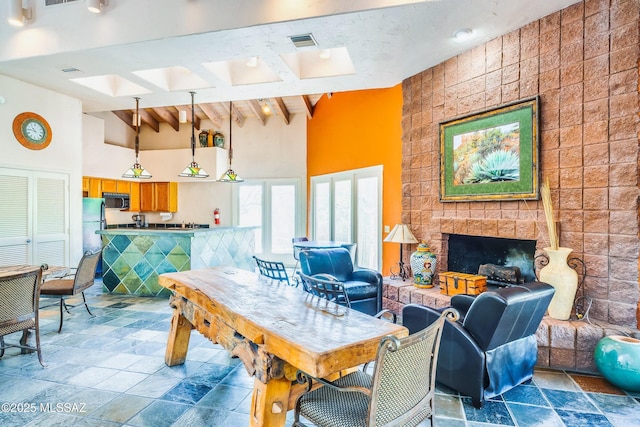 interior space with beamed ceiling, a fireplace, and high vaulted ceiling