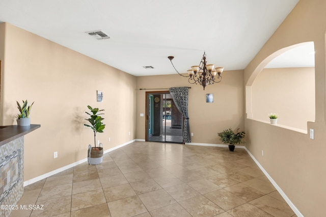 tiled foyer with a notable chandelier