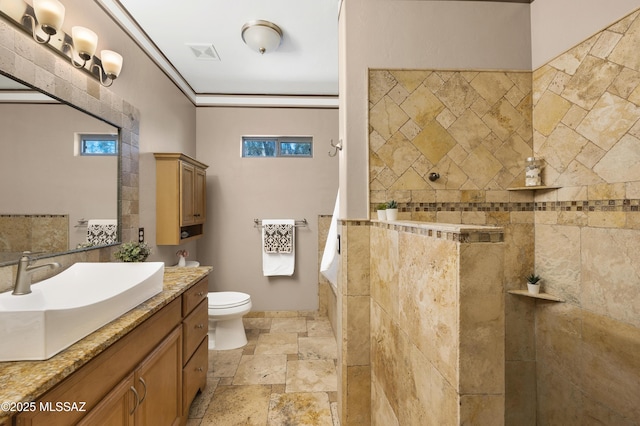 bathroom featuring vanity, crown molding, toilet, and tiled shower