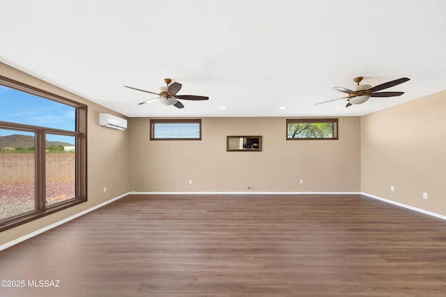 spare room with dark hardwood / wood-style floors, an AC wall unit, and ceiling fan