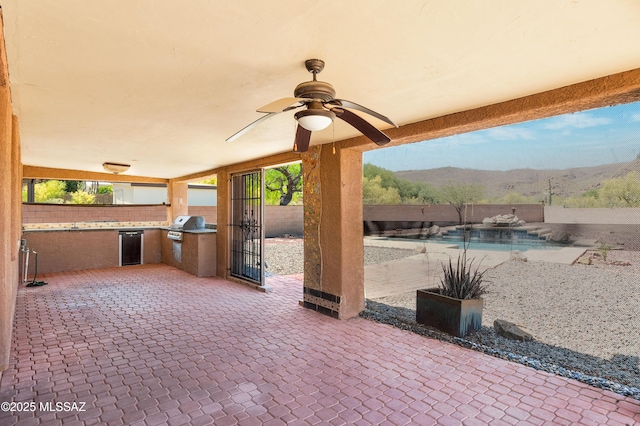 view of patio / terrace with ceiling fan, area for grilling, grilling area, and a mountain view