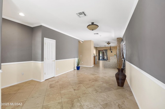 hallway with ornamental molding and light tile patterned flooring