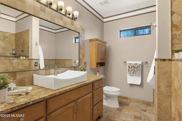 bathroom with crown molding, vanity, and toilet