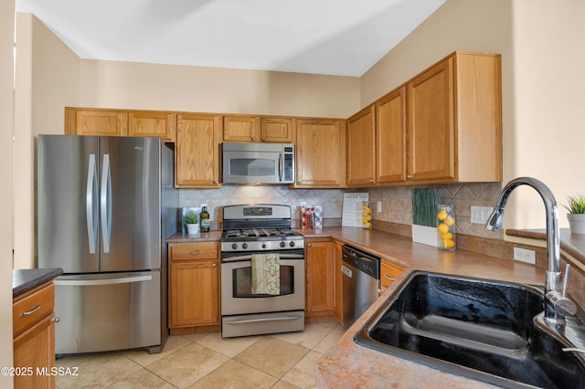 kitchen with tasteful backsplash, sink, light tile patterned floors, and stainless steel appliances