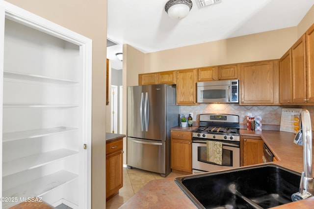 kitchen featuring light tile patterned floors, decorative backsplash, sink, and appliances with stainless steel finishes