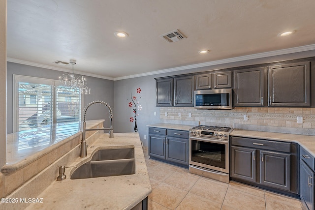 kitchen featuring sink, decorative light fixtures, ornamental molding, appliances with stainless steel finishes, and decorative backsplash