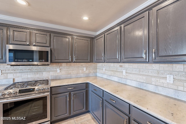 kitchen featuring light tile patterned flooring, crown molding, dark brown cabinets, stainless steel appliances, and decorative backsplash