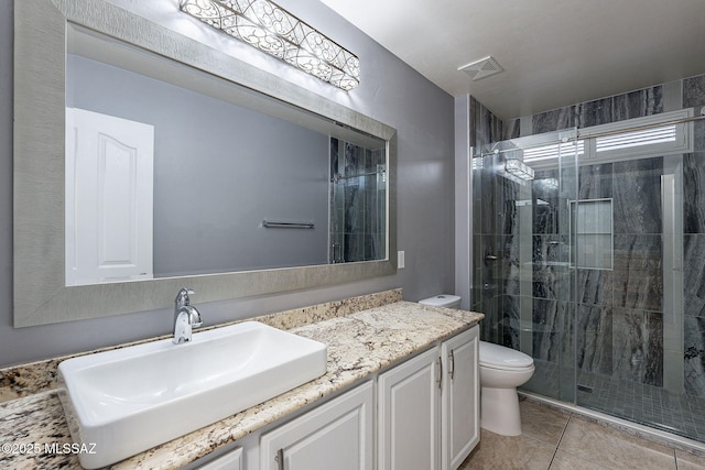 bathroom with vanity, tile patterned flooring, a shower with shower door, and toilet