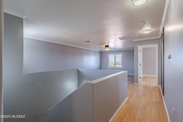 hallway featuring ornamental molding and light hardwood / wood-style floors