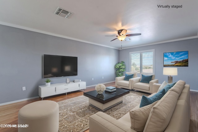 living room with ornamental molding, hardwood / wood-style floors, and ceiling fan