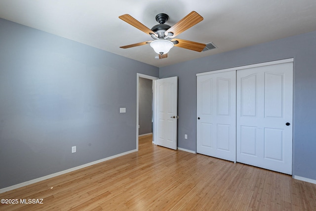 unfurnished bedroom featuring ceiling fan, light hardwood / wood-style floors, and a closet