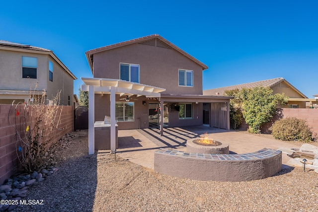 rear view of house with a pergola, a fire pit, and a patio