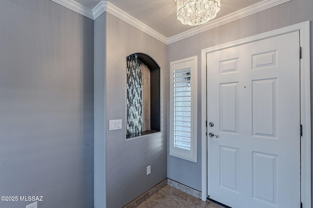 tiled entryway with ornamental molding and an inviting chandelier