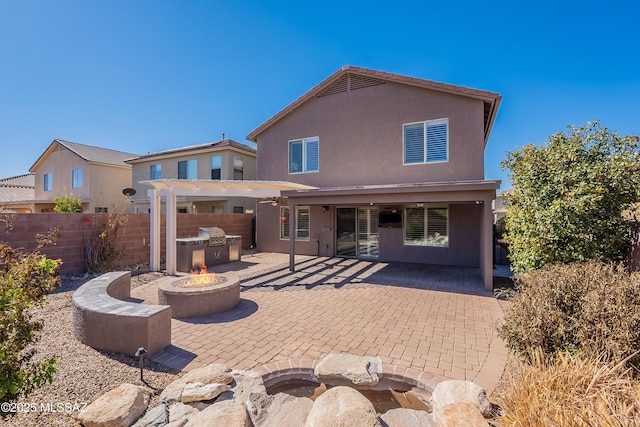 back of house featuring a patio, a pergola, and a fire pit