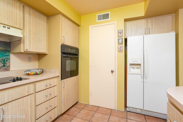 kitchen featuring light tile patterned floors, light countertops, visible vents, light brown cabinetry, and black appliances