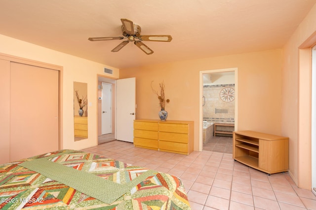 unfurnished bedroom with light tile patterned floors, a closet, visible vents, a ceiling fan, and connected bathroom