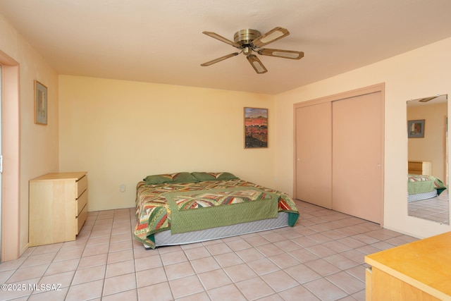 bedroom featuring a ceiling fan, a closet, and light tile patterned flooring