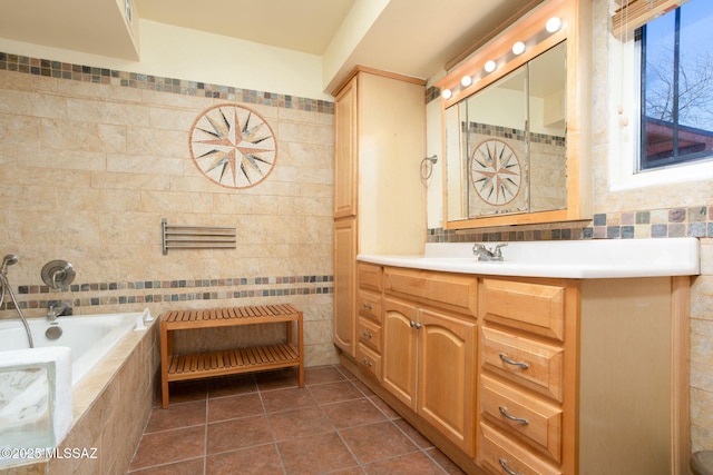 full bath with a relaxing tiled tub, vanity, and tile walls