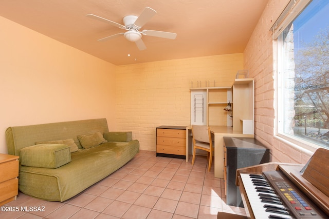 living room with ceiling fan, brick wall, and light tile patterned flooring