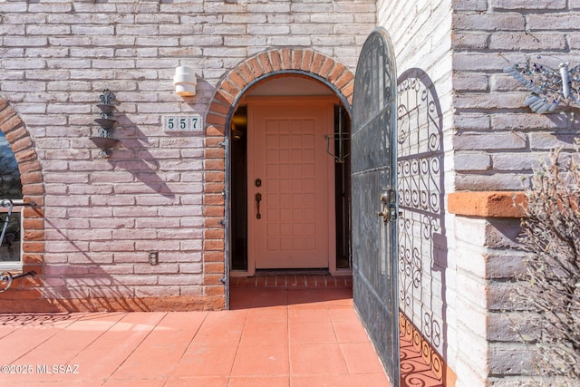 view of exterior entry featuring brick siding