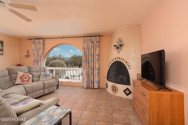 living room featuring light tile patterned flooring, a fireplace, and a ceiling fan