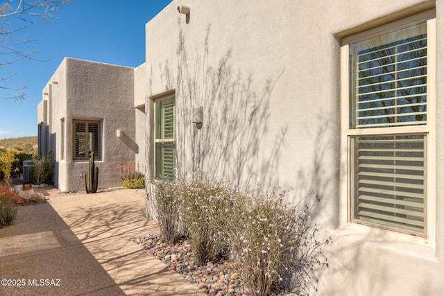 view of property exterior featuring central air condition unit, a patio area, and stucco siding