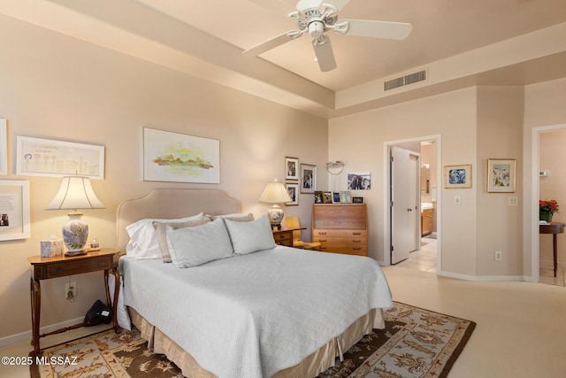 bedroom with visible vents, a ceiling fan, light carpet, connected bathroom, and baseboards