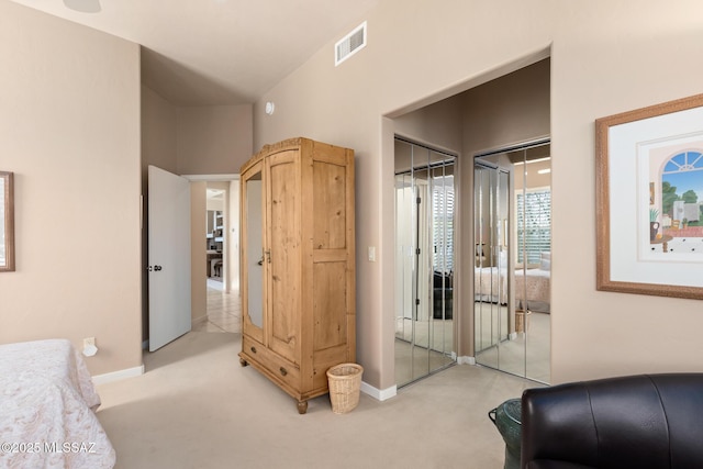 bedroom featuring baseboards, visible vents, and light colored carpet