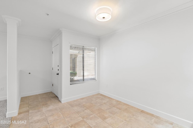 spare room with crown molding and decorative columns