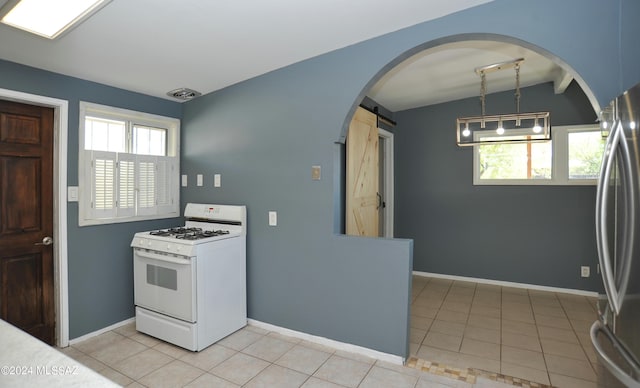 kitchen with vaulted ceiling, light tile patterned floors, stainless steel fridge, white gas range, and a barn door