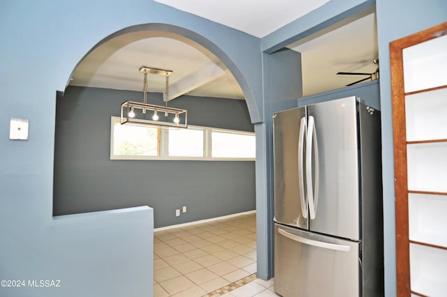 kitchen with light tile patterned floors, stainless steel refrigerator, and beamed ceiling