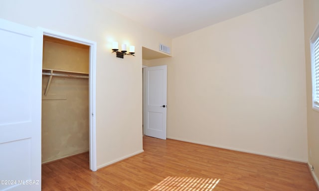 unfurnished bedroom with light hardwood / wood-style floors and a closet