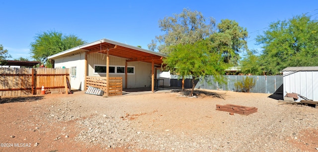 back of house featuring a storage shed