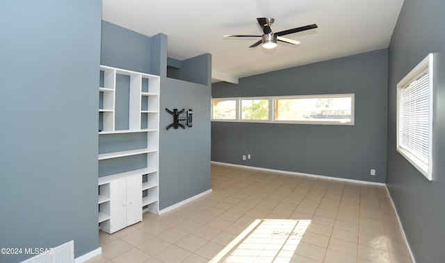 empty room with light tile patterned flooring, lofted ceiling, and ceiling fan