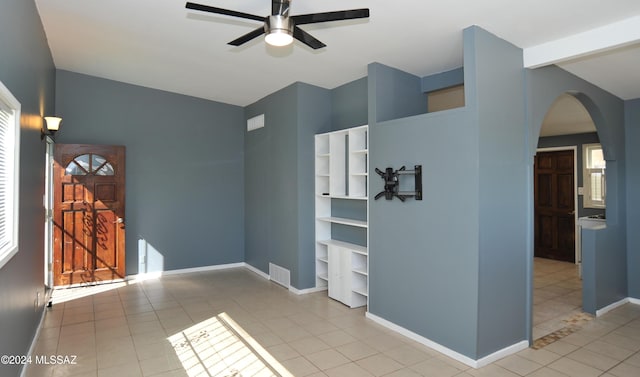 tiled spare room with vaulted ceiling and ceiling fan