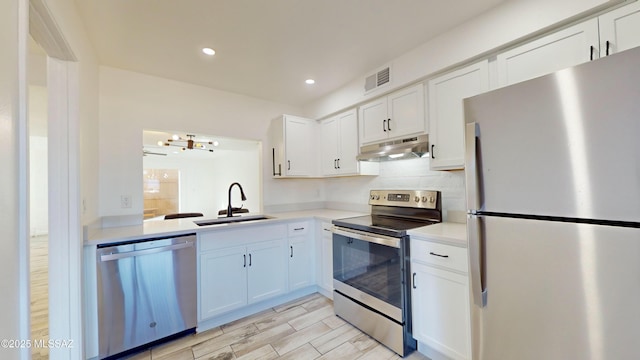 kitchen featuring white cabinetry, appliances with stainless steel finishes, sink, and backsplash