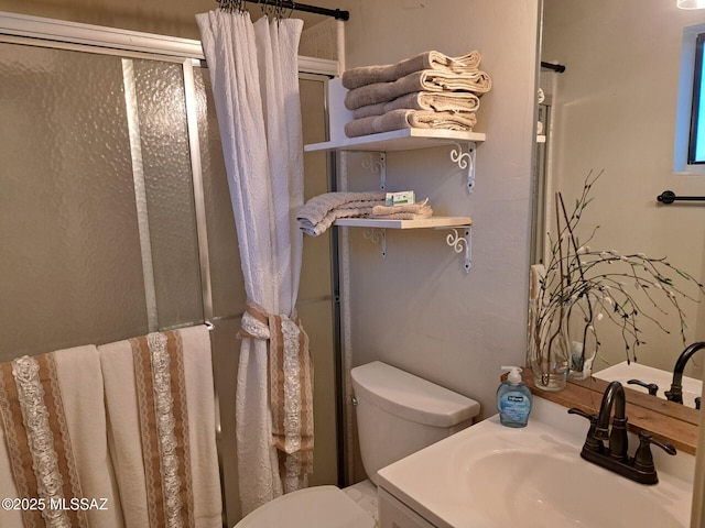 bathroom with vanity, toilet, and walk in shower