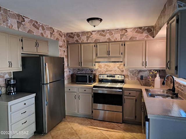 kitchen featuring tasteful backsplash, stainless steel appliances, light tile patterned flooring, and sink